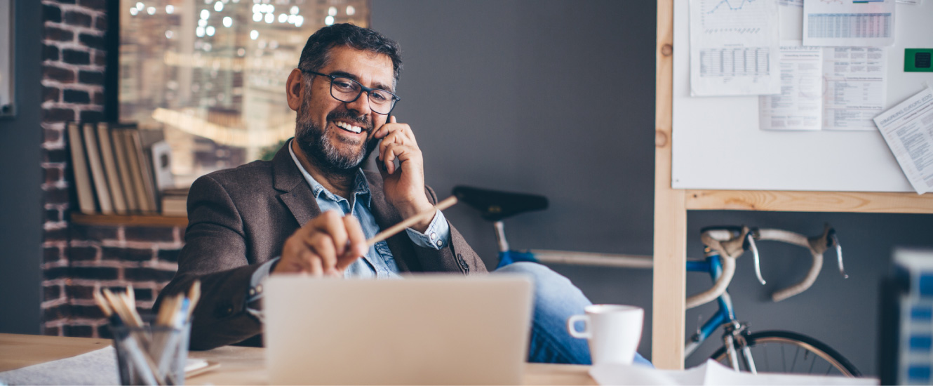 Middle-aged business man on the phone inside a modern office.